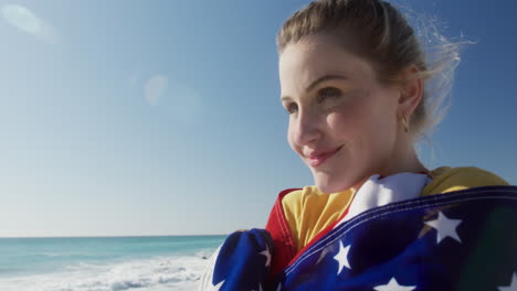 woman holding american flag on the beach