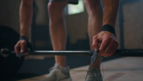 tomada amplia de un joven atleta caucásico de levantamiento de pesas extremo que hace ejercicio con pesas pesadas en un gran gimnasio hardcore.
