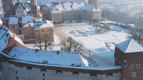 snow-covered wawel castle at magic morning with soft sun light during winter, krakow, poland