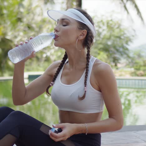 Sporty-female-drinking-water-during-workout