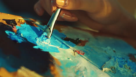 woman mixing paints on artist palette. oil painting on canvas.