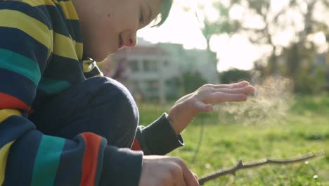 side view, tight shot of caucasian cute boy, removing soil form his hand, using a wooden stick