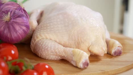 raw chicken with vegetables on a cutting board