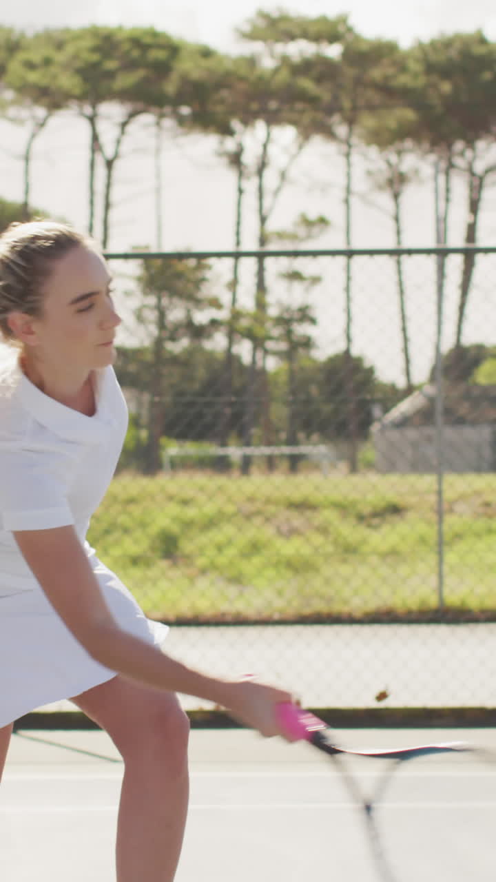 라켓 을 들고 친구 와 함께 훈련 하는 백인 여자 테니스 선수 의 중간 부분 의 비디오