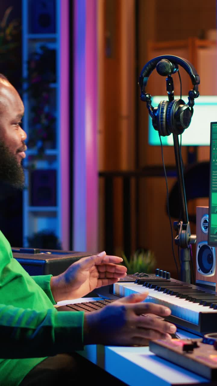 Uomo afroamericano che suona una tastiera MIDI in uno studio musicale