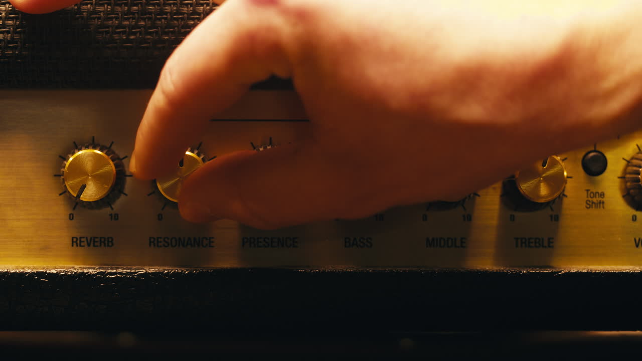 자크를 기타 증폭기에 연결하고 볼 노브를 켜고 라이브 콘서트 쇼, 기타 튜브 증폭기에서 음악을 연주하는 클로즈업.