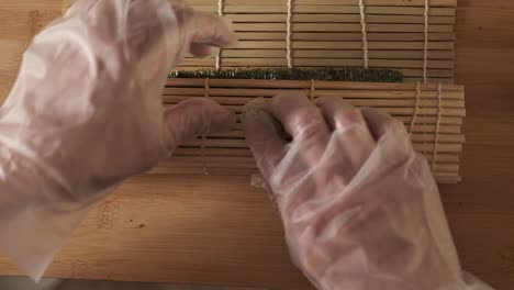 topshot of chef rolling sushi rolls in the kitchen