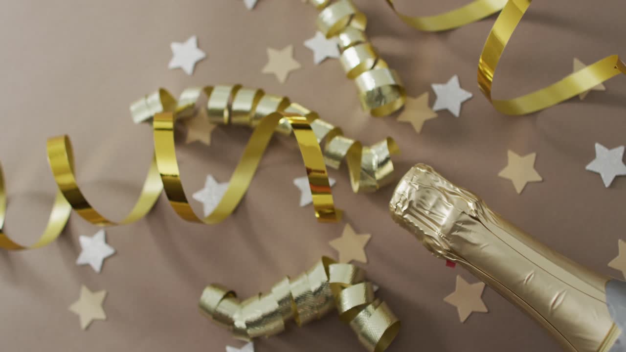 Champagne bottle with decorations and stars on green background at new year's eve