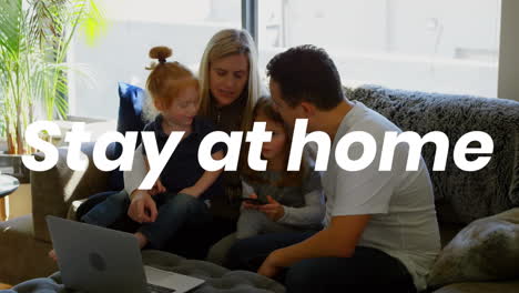 animation of stay at home text over parents with son and daughter using laptop at home