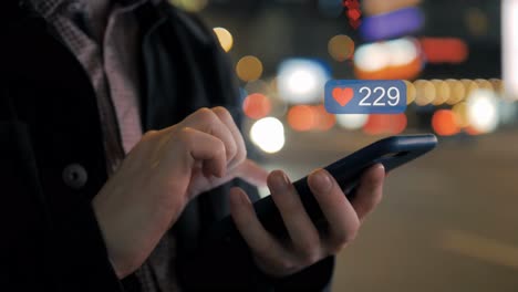 Person using a smartphone at night, showing likes on a social media app