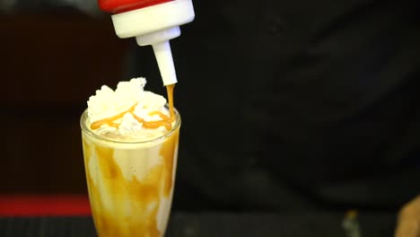 caramel being poured on milkshake. slow motion