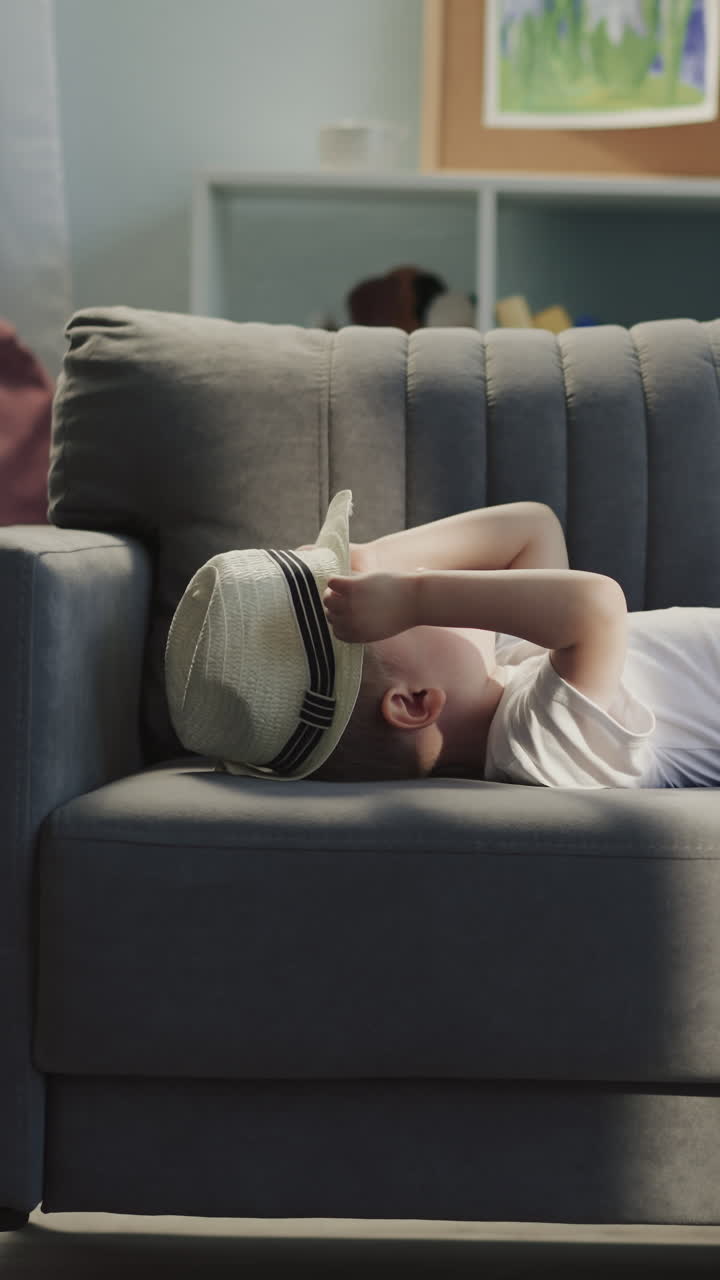 유치원 소녀는 소파 주위를 가방을 끌고 다니는 동안 유아 형제는 거실에서 파나마와 함께 놀고 있습니다. 여름 휴가를 위해 준비 된 귀여운 아이들