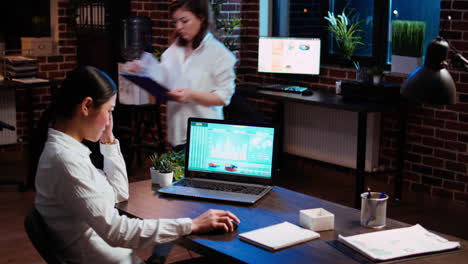 Businesswoman-concerned-about-statistical-data-financial-graphs-on-laptop