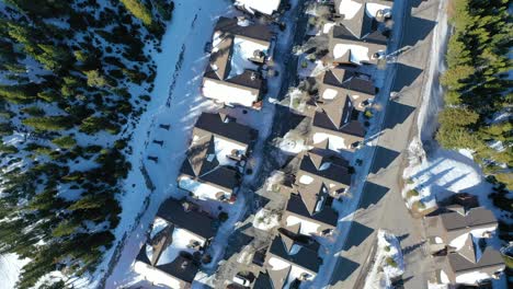 overhead drone footage captures peaceful winter condos in big sky montana dusted in snow, surrounded by pines and scenic slopes, offering visitors a picture-perfect holiday lodging option