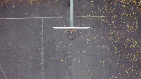 disparo de dron subiendo directamente sobre una cancha de baloncesto en un parque público