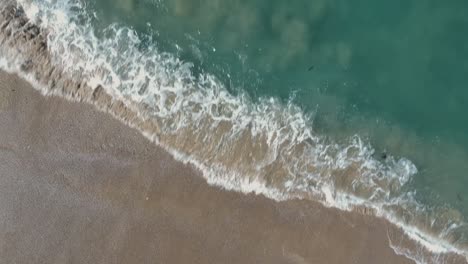 Afternoon-camera-down-closer-drone-view-from-the-deeply-and-foamy-waves-of-Redondo-Beach,-California