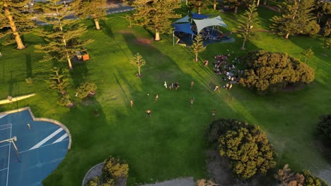 Gruppe-Von-Freunden,-Die-Bei-Sonnenuntergang-In-Australien-Mit-Ball-Im-Fremantle-South-Beach-Park-Spielen