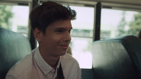 Un-Colegial-Indio-Sonriente-Hablando-En-Un-Autobús-Escolar-De-Cerca.-Retrato-Feliz-Estudiante.
