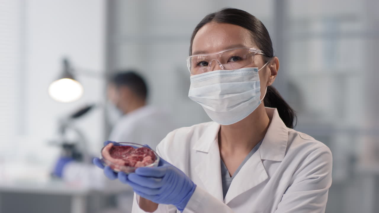 Scientist examining a meat sample in a lab
