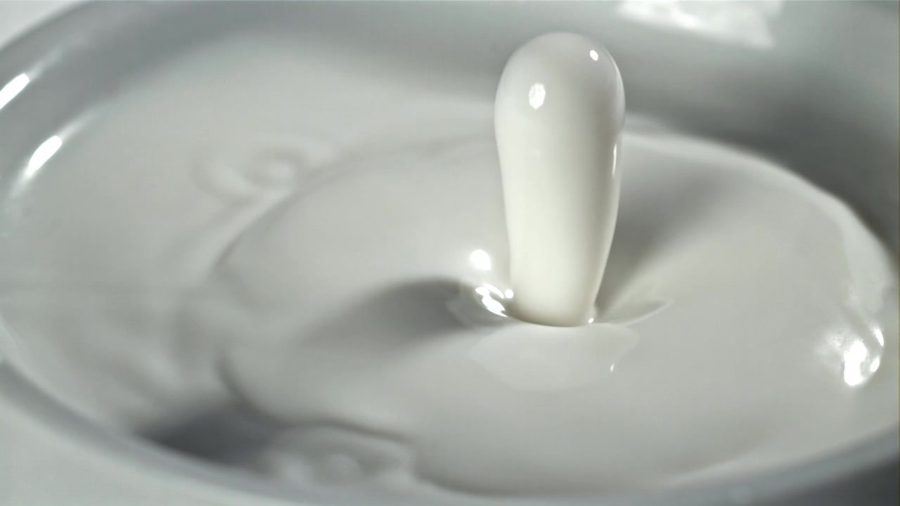 Slowmotion: Mælkedråbe skaber et kroneplask og ringe i vandet