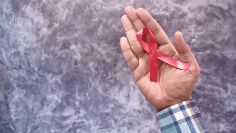 red ribbon in hand