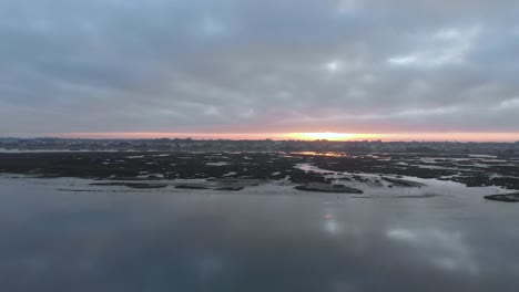 aerial view during sunrise of a small village on a natural reserve and it´s river