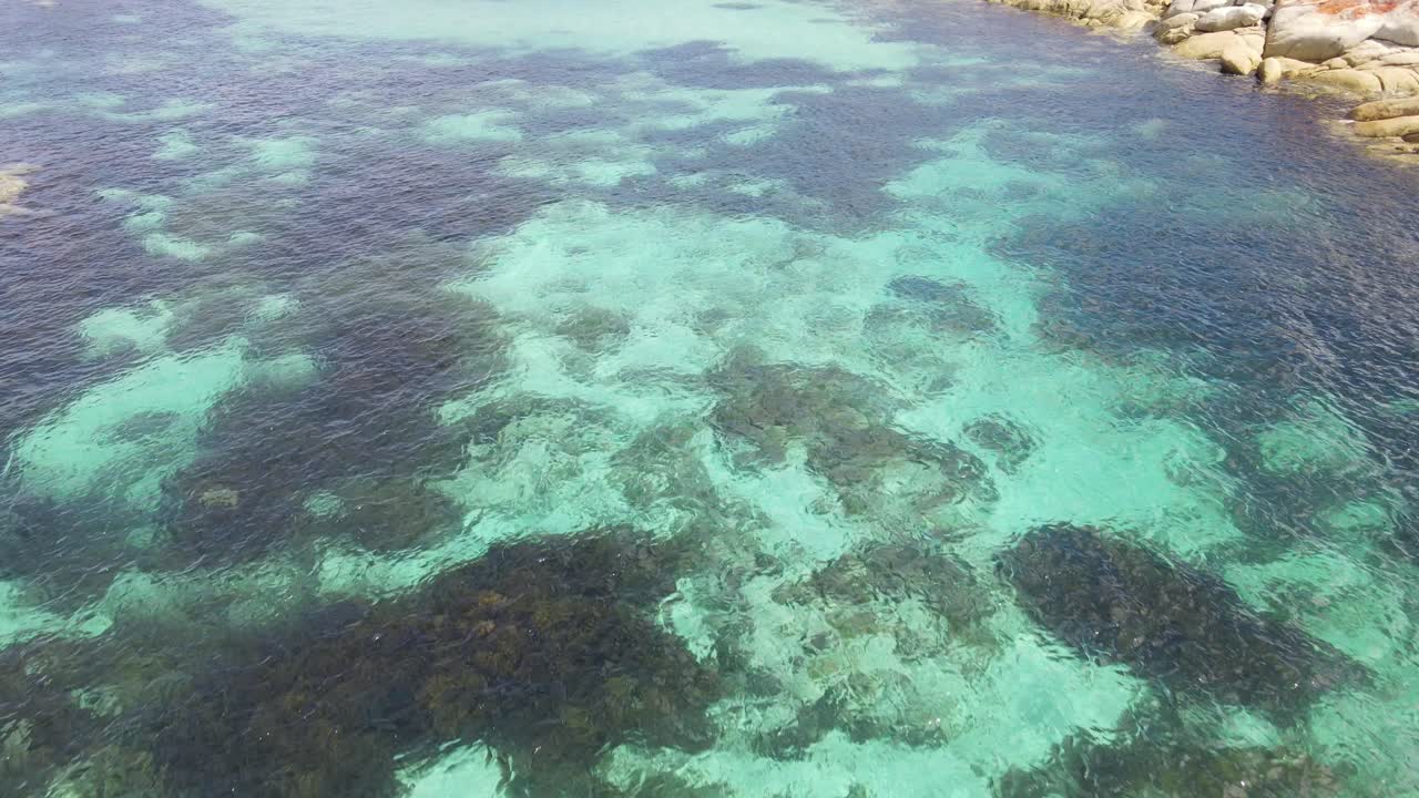 drone aéreo sobre agua tropical azul pan up parque tasmania cámara lenta 60fps