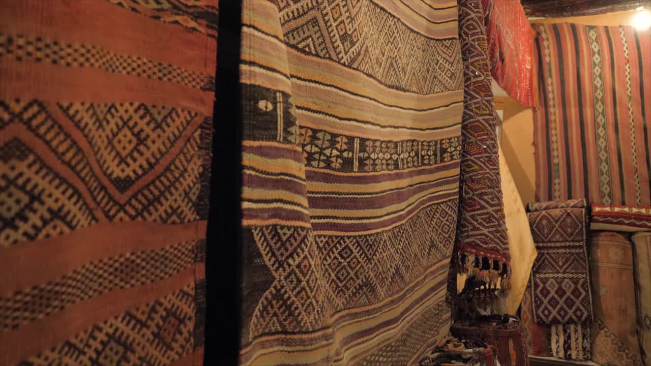 Close up of colorful rugs are hanged . slow pan upward.Patchwork carpet for sale in local market.