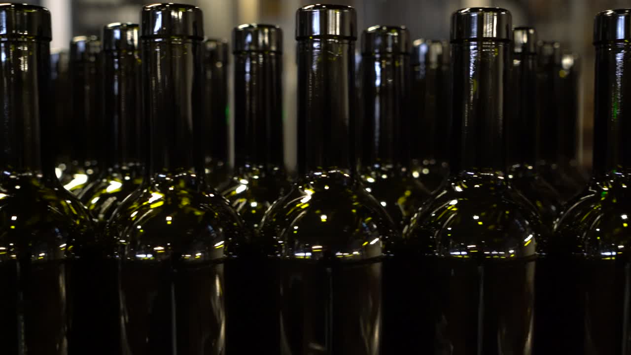 botellas vacías que se mueven a lo largo de una cinta transportadora para ser llenadas y etiquetadas para su venta y distribución, aisladas