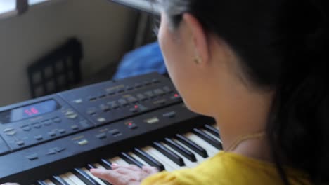 long, ultra high definition, handheld shot of an asian girl on keyboard in living room