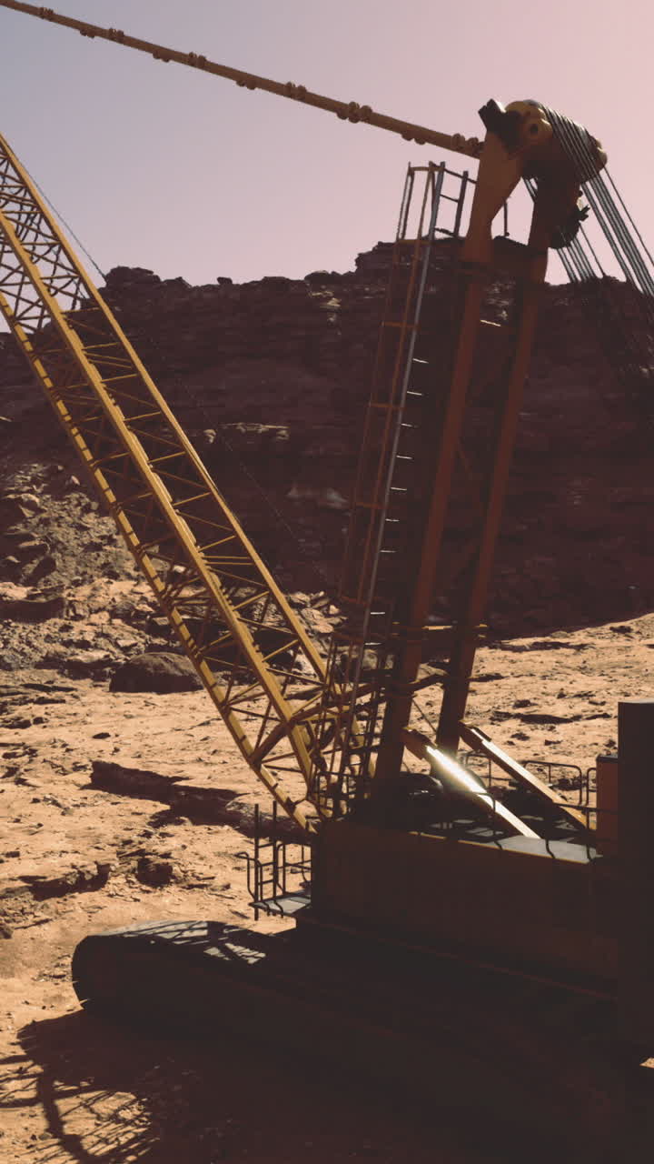 Heavy machinery works on rocky terrain during golden hour