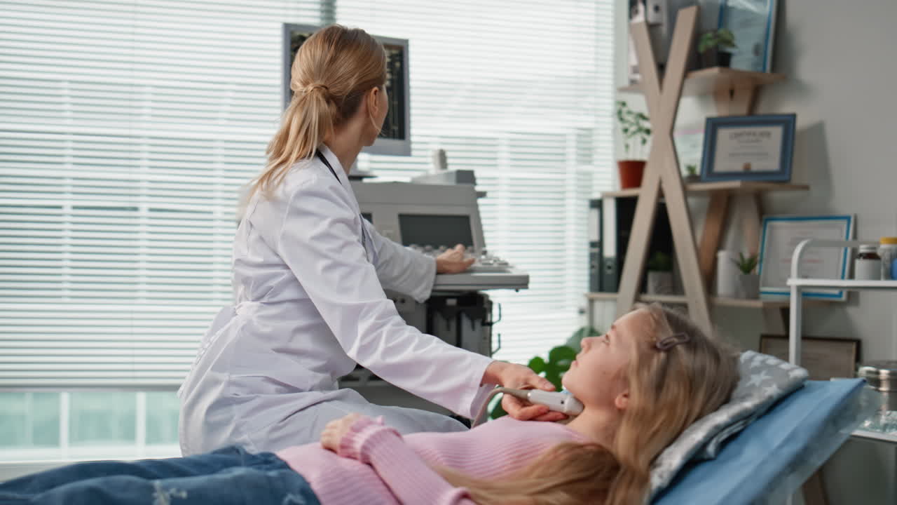 Medical professional performing ultrasound on girl. Child care scan equipment