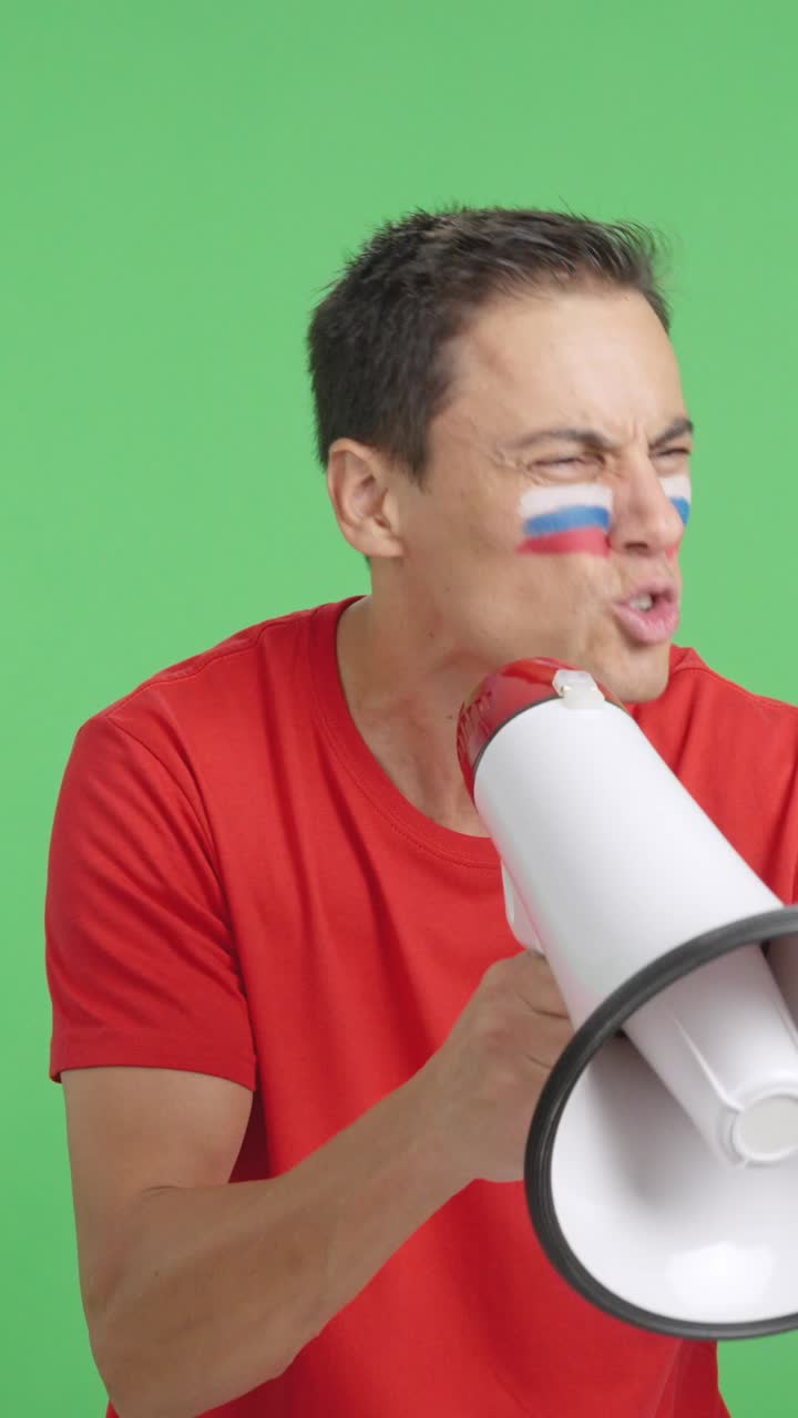 Excited man with russian flag on face using a megaphone