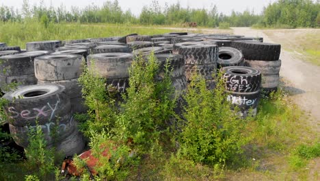 video de drones de 4k de una pila de neumáticos de excavadoras gigantes desechados en el desierto cerca de fairbanks, ak durante el día de verano-3