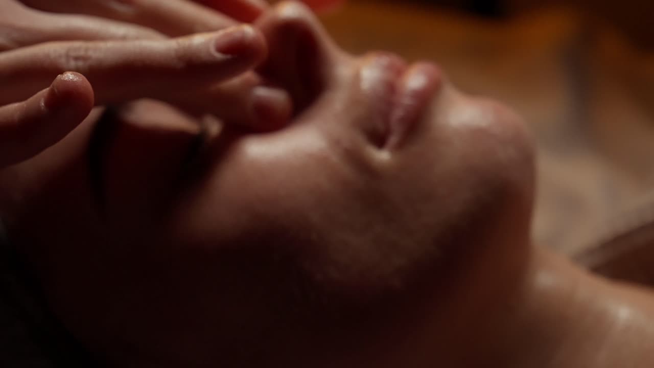 Nærbillede af kvinde, der får afslappende ansigtsmassage på et spa