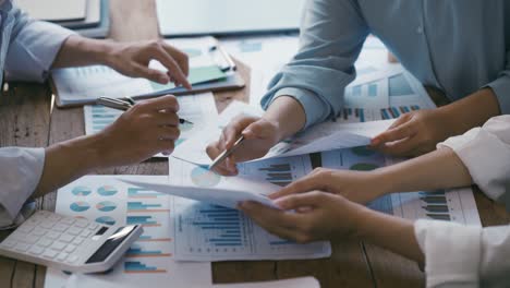 business professionals working together at office desk, hands close up pointing out financial data on a report, teamwork concept. financial and investment.