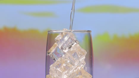 pouring water over ice cubes in a glass