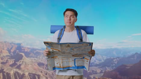 asian male hiker with mountaineering backpack looking at the map then looking around while traveling at the top of mountain