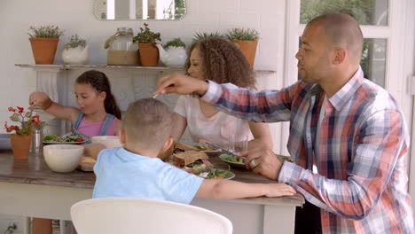 family at home eating meal on outdoor verandah together