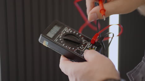 Close-up-of-the-device-of-a-working-electrician-checking-the-presence-of-voltage-in-the-network