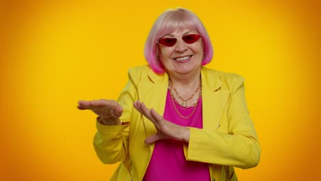stylish older woman with pink hair and sunglasses