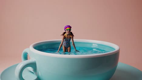 una chica nadando en una taza de té gigante.