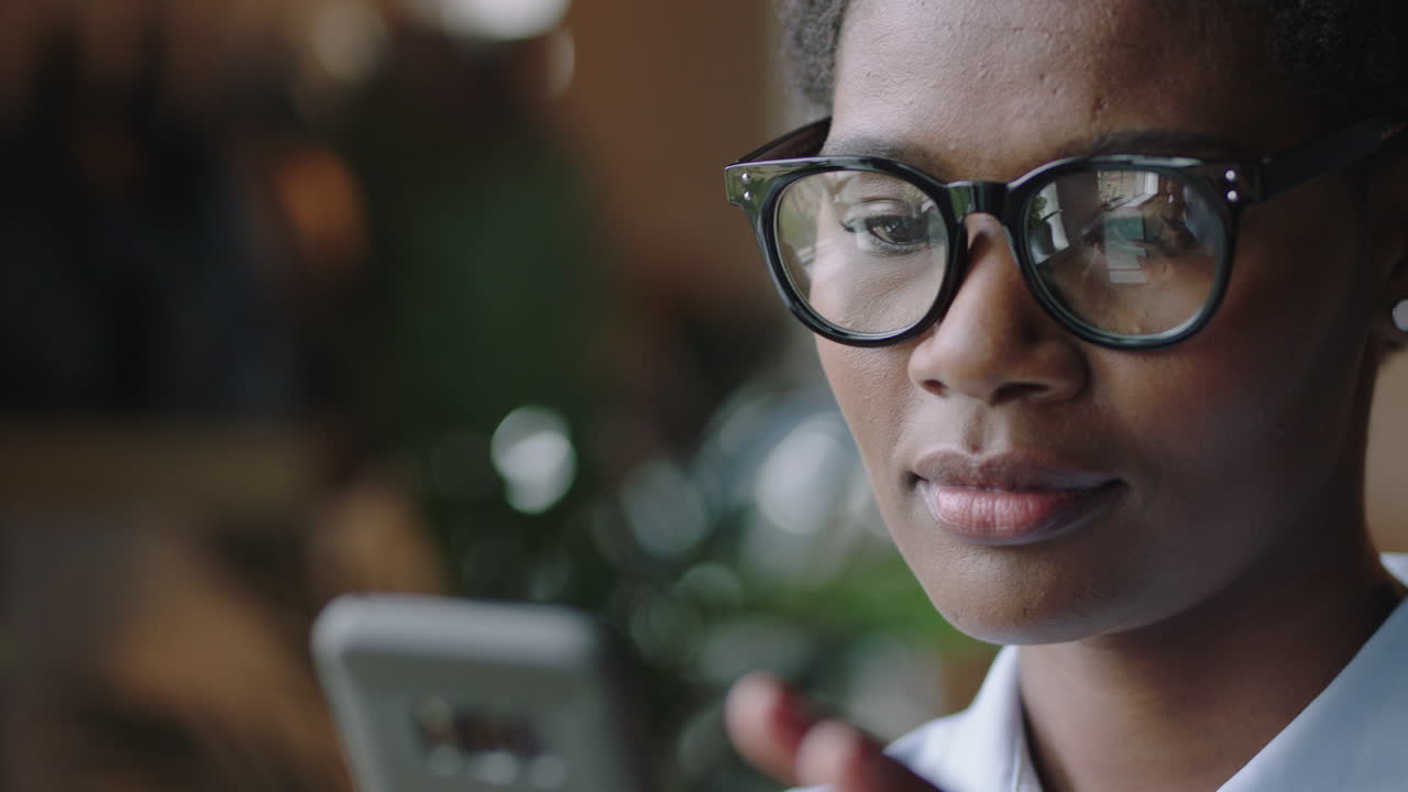 close up portrait young african american business woman in cafe using smartphone browsing online reading email messages networking on social media texting enjoying mobile communication