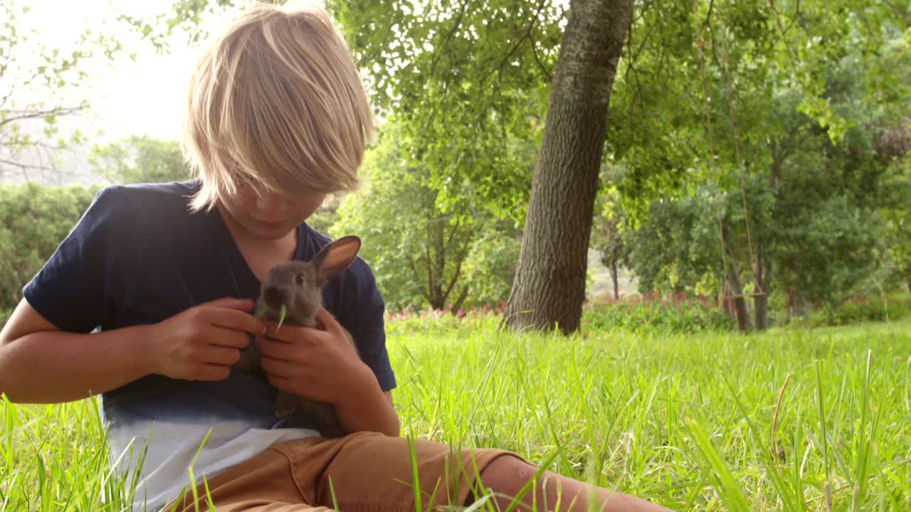 밖에서 토끼를 돌보는 행복한 아이