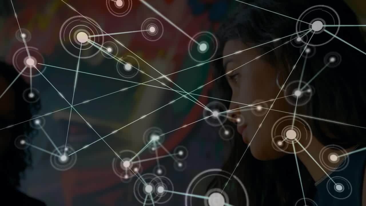 Female colleagues collaborating on tech design, exploring floating network overlay in studio