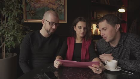 people discussing a menu in a cafe