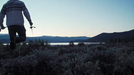 medium silhouette shot of a fisherman walking away from camera