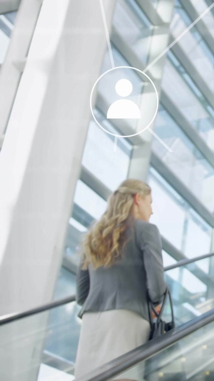 Video vertical: Ejecutivo subiendo a una escalera mecánica en un atrio, generando iconos de usuario ascendentes para networking.