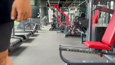 two trainers walk through a well-equipped gym, discussing fitness routines. bright lighting and modern equipment create an energetic atmosphere