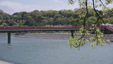 red bridge across uji river, early summer in japan